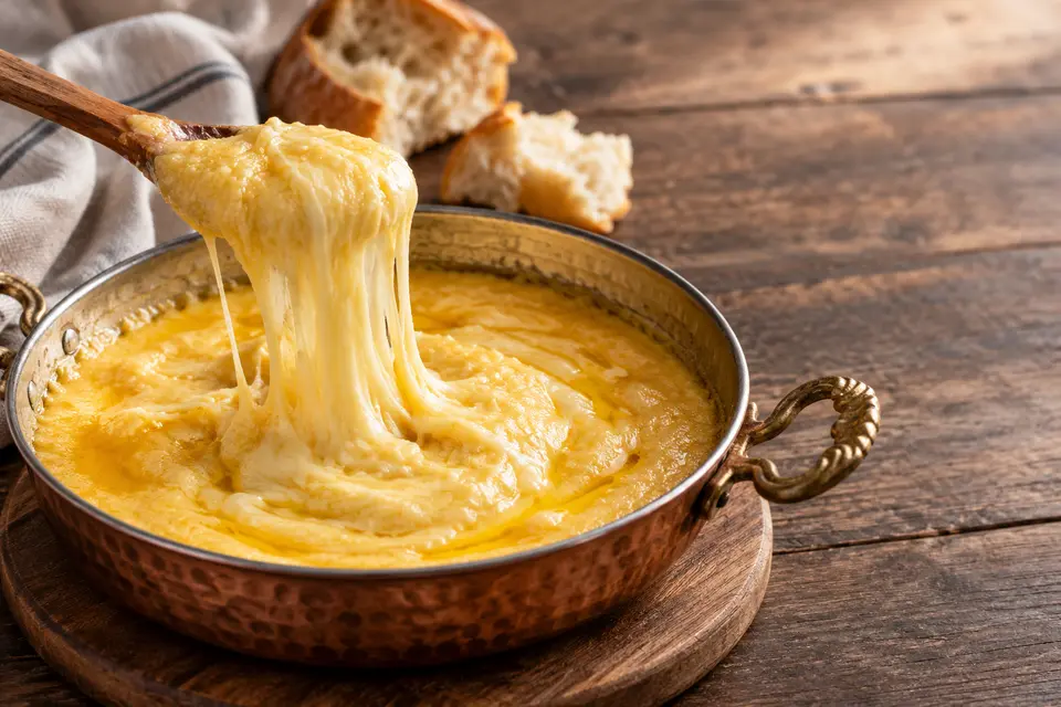 Trabzoner Kuymak in einer Kupferpfanne mit goldenem Maismehl, Butter und langziehendem geschmolzenem Käse